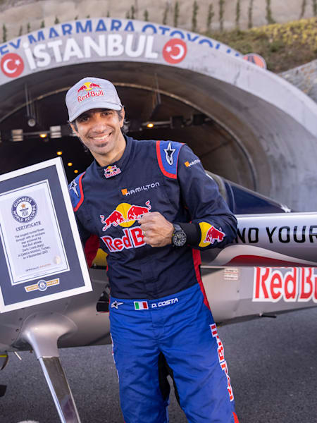 Dario Costa posiert mit seinem Guinness World Record-Zertifikat vor seinem Stuntflugzeug in Istanbul in der Türkei.