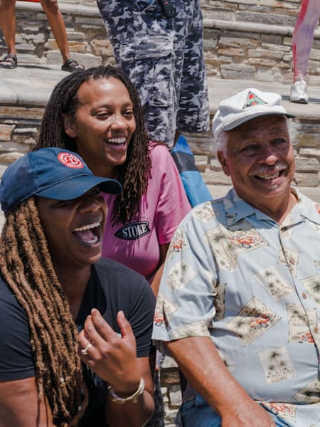 Gigi Lucas, the founder of SurfearNEGRA, Tony Corley, founder of the Black Surfers Association, and Sharon Schaffer, the first Black Female professional surfer, pose for a photo.