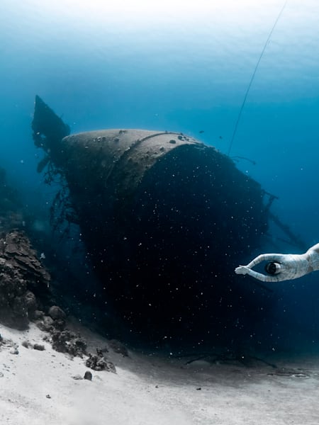 Christin posiert nahe der Karibik­insel Bonaire vor einem Schiffswrack. 