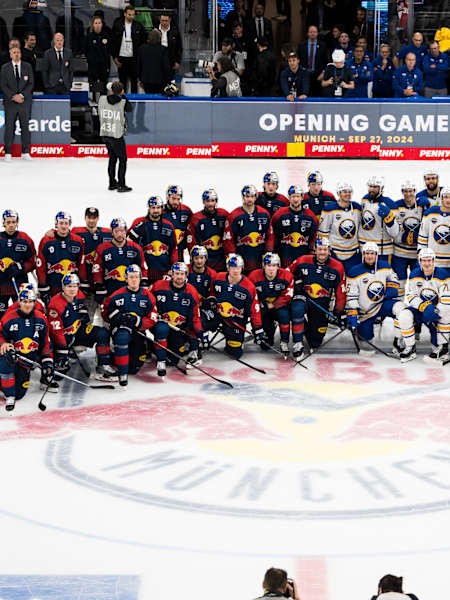 D’Teams vom EHC Red Bull München und de Buffalo Sabres posiere vor em Opening Game.