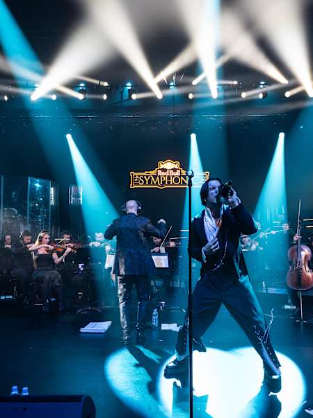 Experience Baby Lasagna delivering an electrifying performance at Red Bull Symphonic 2025, held at HNK2 in Zagreb, Croatia, with a full orchestra under dynamic stage lighting