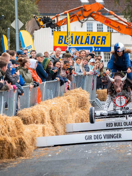 A creative homemade soapbox car blasts through the track at Red Bull Olabil 2025 in Trondheim, Norway, with cheering fans lining the course for this adrenaline-packed racing event
