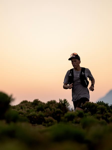 Ultra runner Ryan Sandes powers through the Cape Town wilderness during a Cocodona 250 training run at sunrise on March 3, 2025, embodying Red Bull adventure and endurance