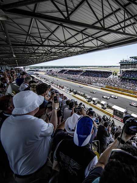 Les voitures s'élancent au départ des 24 Heures du Mans devant des tribunes combles.