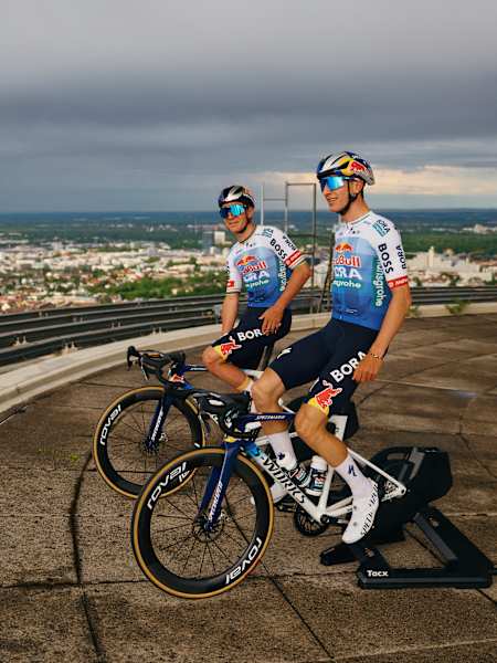 Florian Lipowitz und Remco Evenepoel enthüllen Red Bull - BORA – hansgrohes 13. Tour de France-Trikot bei Rundfahrt auf dem Münchner Olympiaturm.