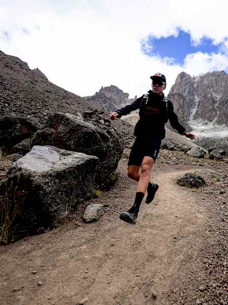 Ryan Sandes runs along a rugged trail beneath Mount Kenya’s dramatic peaks during the 2026 Mt Kenya Expedition in Kenya
