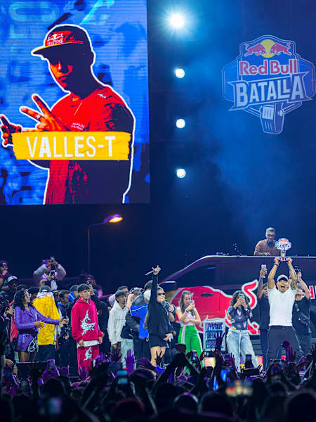 Valles T levanta el trofeo tras ganar la final nacional de la Red Bull Batalla en Bogotá, Colombia, el 2 de octubre de 2025, mientras los fans lo celebran bajo las luces del escenario
