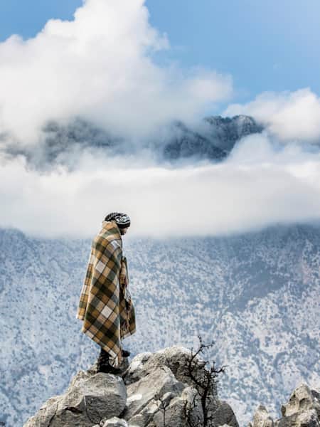 En mann står på toppen av et fjell
