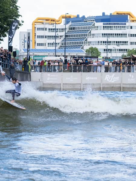 Ben Larg surft op een golf tijdens de opening van het RiF010 evenement in Rotterdam