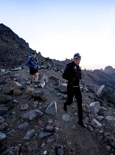 Ryan Sandes leads a rocky high-altitude run during the Mount Kenya Expedition in Kenya on 4 August 2026, with dramatic volcanic peaks stretching into the distance