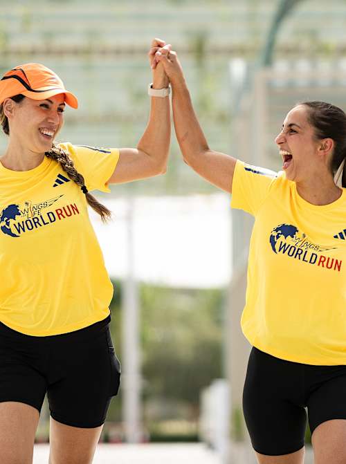 Participants holding hands raised in air during Red bull Wings For Life World Run 2024 at Expo Village in Dubai, United Arab Emirates 