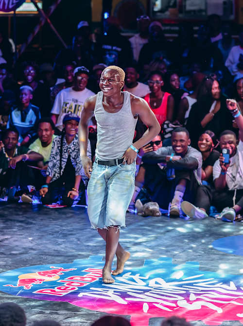 On March 29, 2025, dancers captivate the crowd at Truck Central during the Red Bull Dance Your Style Abuja Qualifier in Nigeria, showing off vibrant street dance moves under dynamic lighting