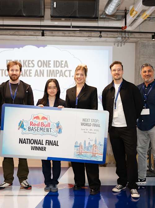 Joi Lam Chow poses with judges holding the Red Bull Basement National Final Winner board on stage at Red Bull Canada HQ in Toronto, Ontario.