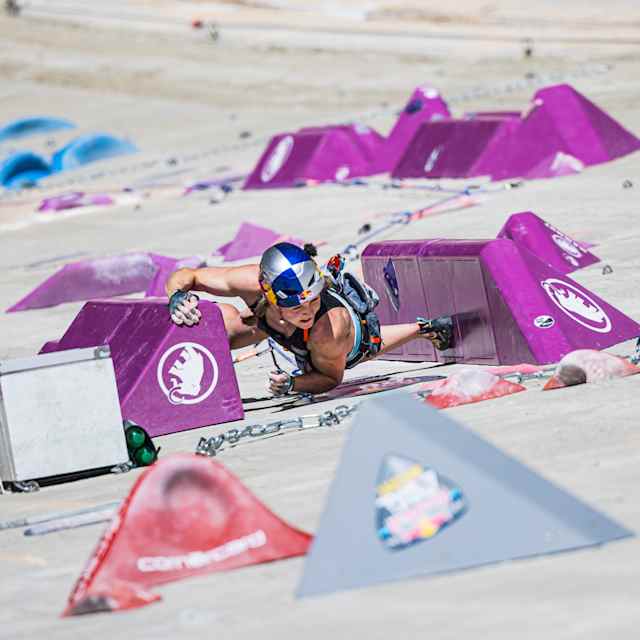 In 2024, Jessica Pilz climbs a vibrant purple climbing wall at the 2024 Red Bull Dual Ascent event in Verzasca, Switzerland