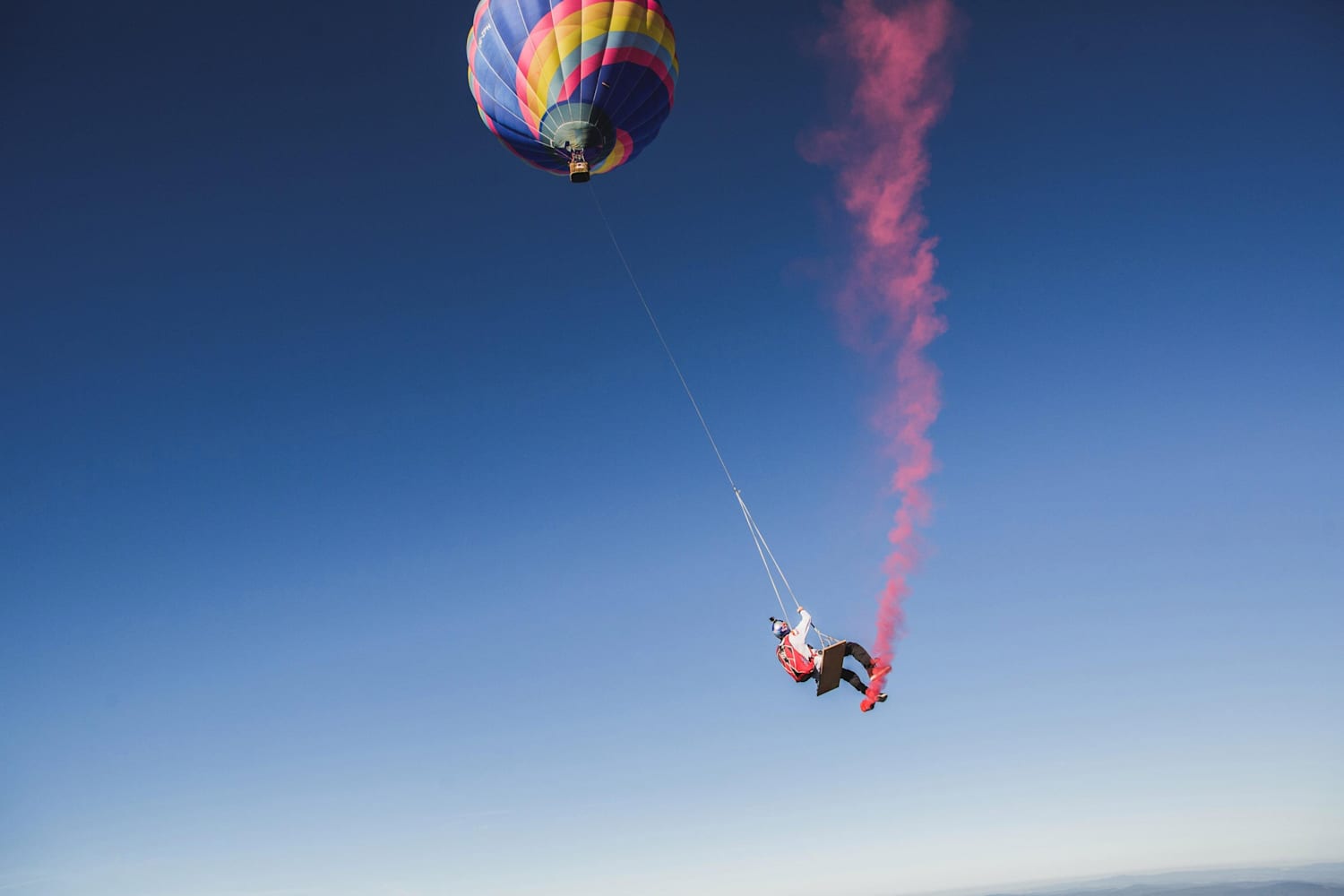 Watch skydivers play on a hot air balloon swing