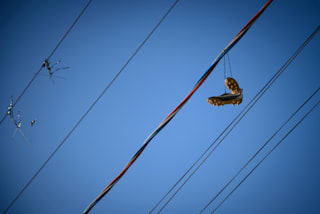 football boots hang from an electricity wire