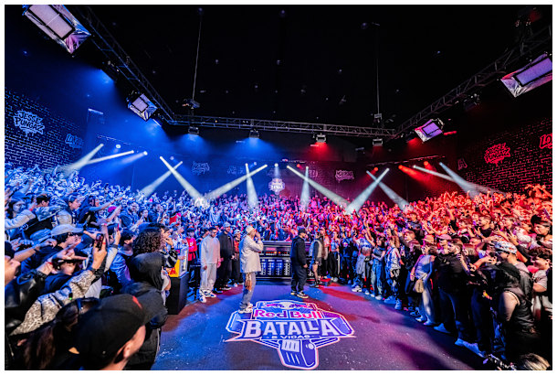The atmosphere soars at Red Bull Batalla 5 Vidas in Bogota, Colombia, as MCs face off on October 18, 2025, under vibrant lights and a roaring crowd, capturing the heart of urban freestyle