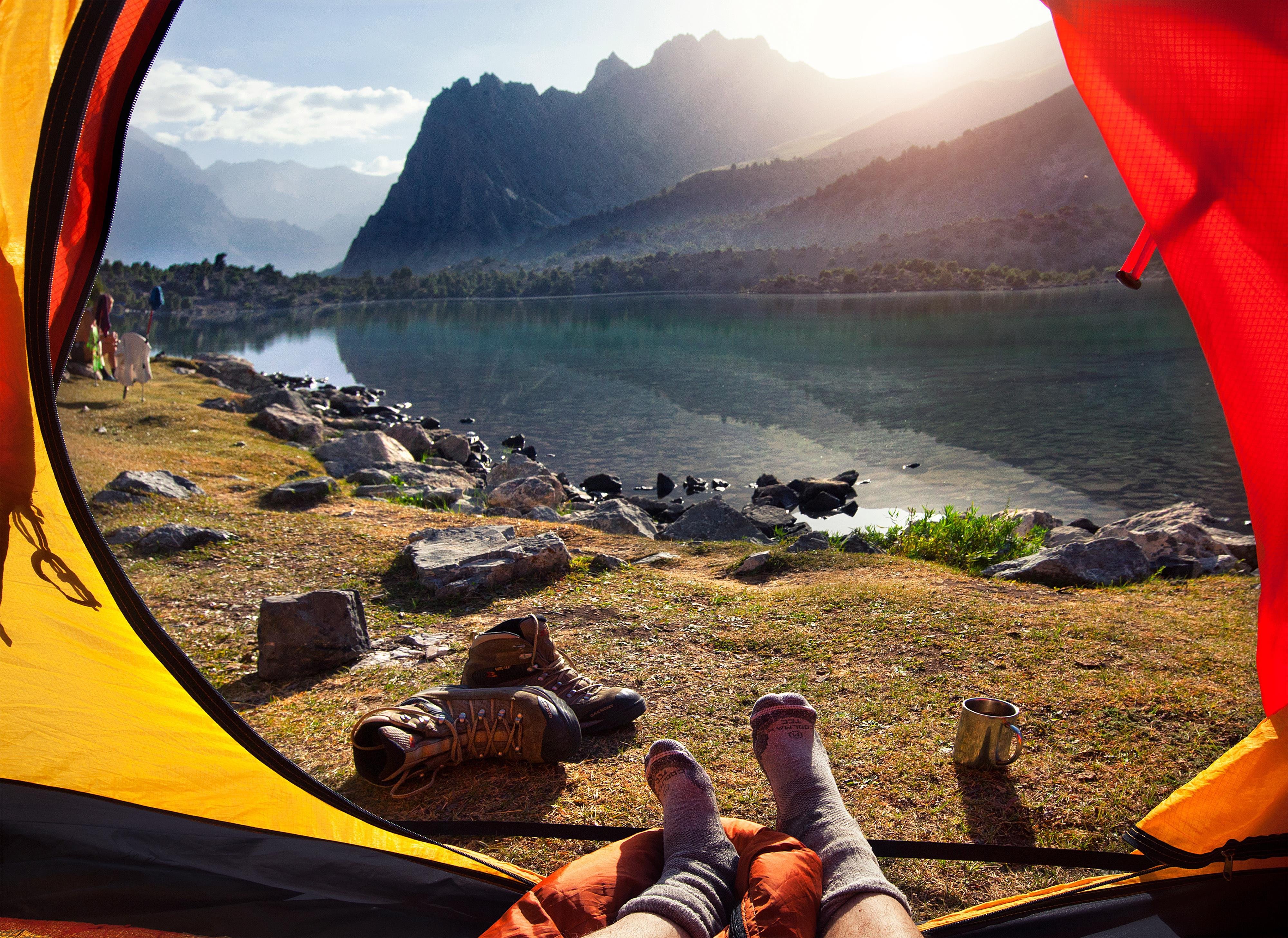 Туристы отдыхают на озере. Шикарный вид из палатки. Красивый вид из палатки. Вид из палатки на горы. Поход вид из палатки.