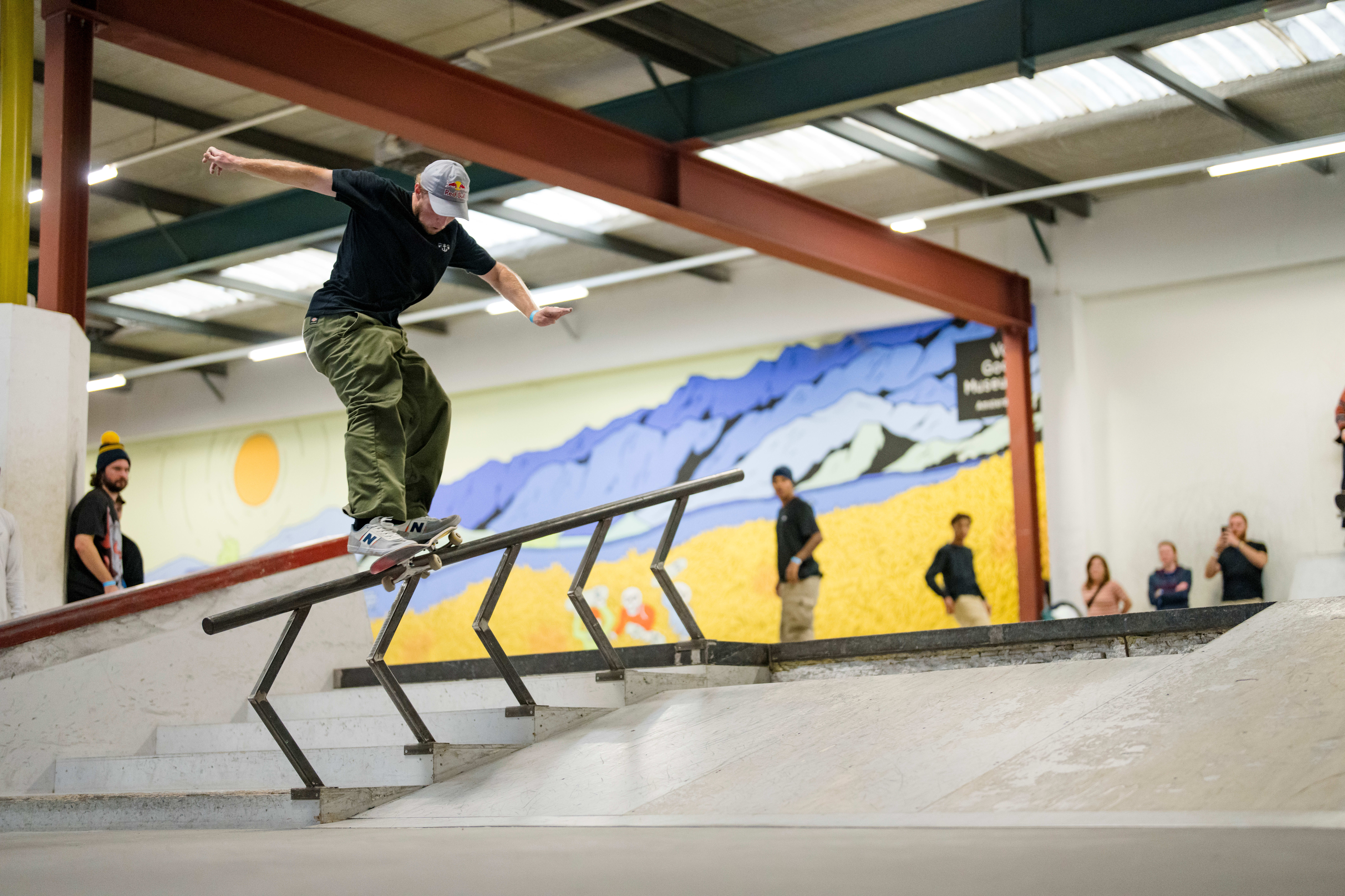 Cool young roller blader female grinding on a rail in a skatepark