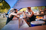 Red Bull Brand Ambassador spricht mit einer Frau an einer Bar auf einem Outdoor Event