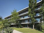 German Red Bull main office as a workplace for creativity, collaboration and interaction with a green space and trees in the front  