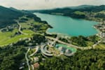 Austrian Red Bull headquarter in Fuschl am See from a distant view near a lake and surrounded by green landscape