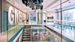 The interiors of the Red Bull headquarter in Germany with a corridor, a staircase on the left side and a Formula 1 car suspended from the ceiling