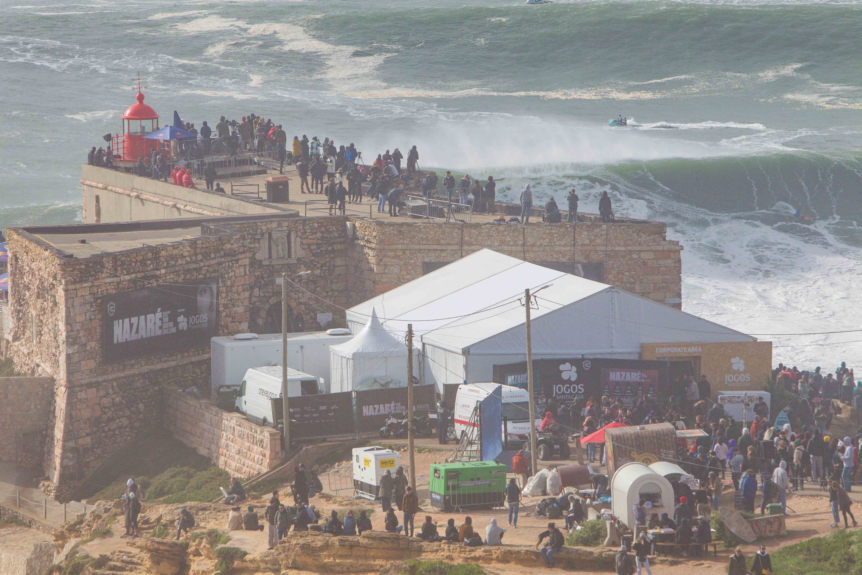 A wave breaks in front of the cliffs in Nazaré, Portugal